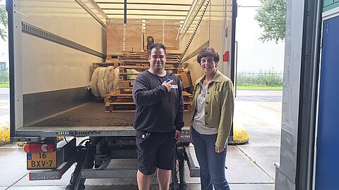 Twee personen voor een vrachtwagen.