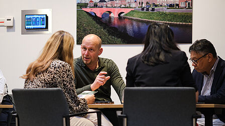 Vier personen aan een tafel.