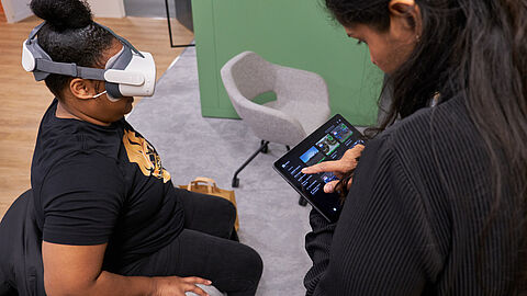 Vrouw zit met een VR-bril op haar hoofd.