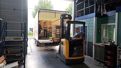Heftruck rijdt pallets in een vrachtwagen.