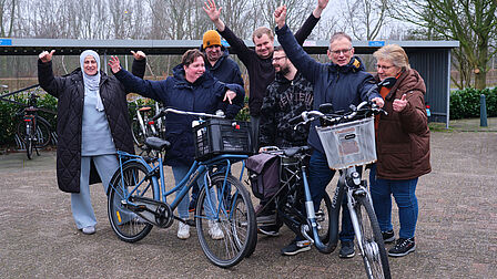 De ondernemingsraad (OR) Groepsfoto van een aantal trotse OR-leden met fietsen.