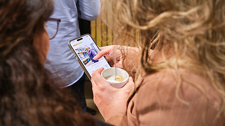 Twee vrouwen bekijken vacatures op een smartphone.